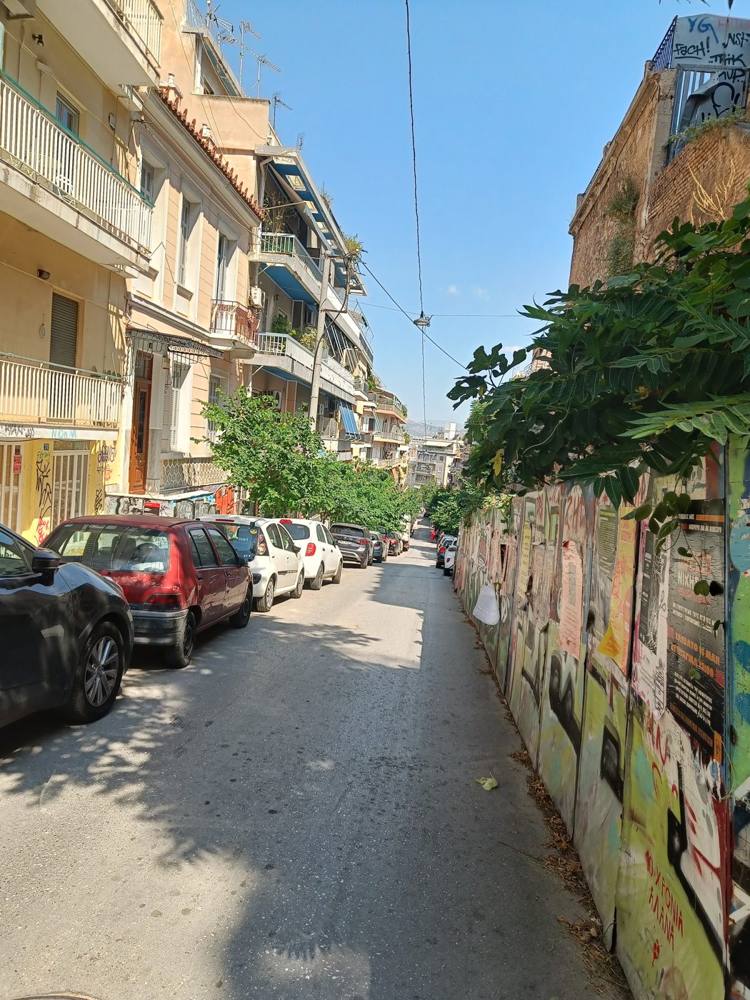 A residential Athens street lined with balconies and parked cars
