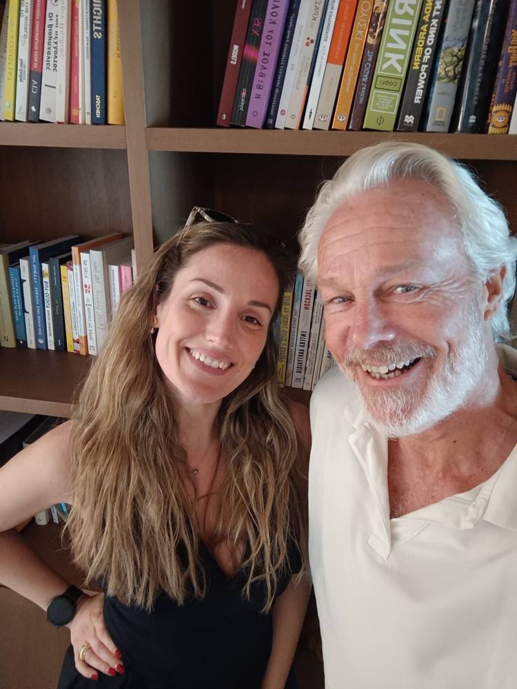 Hans with one of the people he met in Athens, in front of a bookshelf